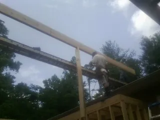 Carpenter setting a ridge beam over a new addition frame — Ice Dam Removal by Roofing Brothers in Meadow Valley