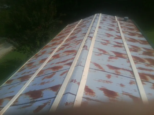 Rusted metal roof panels with new wood purlins before replacement — Storm Damage Roof Repair in Meadow Valley by Roofing Brothers