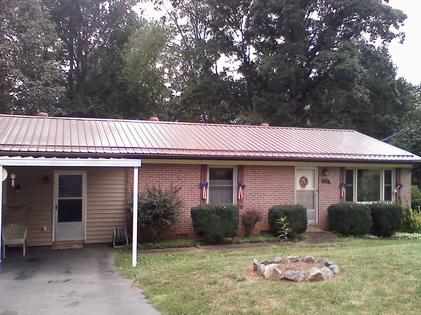 Bronze metal roof and carport on a brick ranch home — Roof Repair work by our crew in Meadow Valley